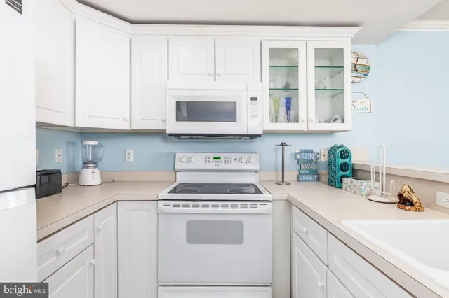 a kitchen with cabinets appliances a sink and a counter top