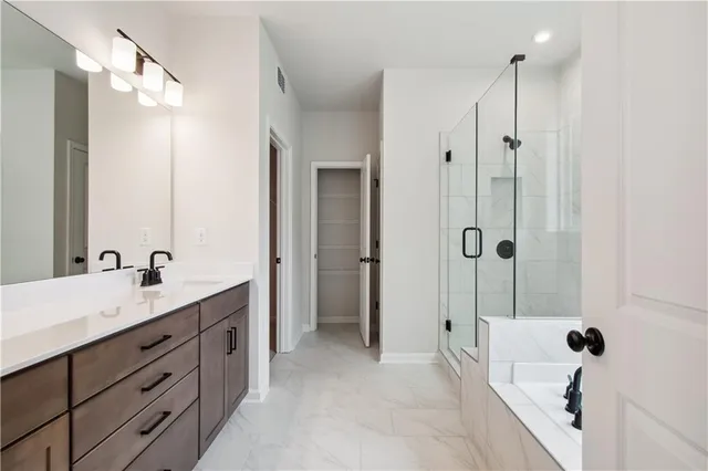 a spacious bathroom with a tub sink shower and mirror
