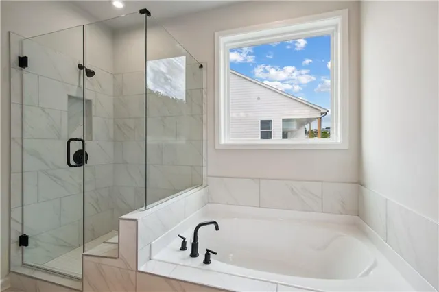 a white bath tub sitting next to a shower