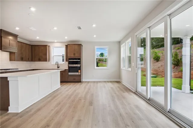 a large kitchen with a large window and stainless steel appliances
