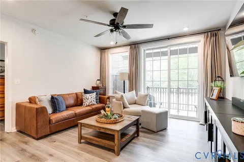 a living room with furniture a flat screen tv and a large window