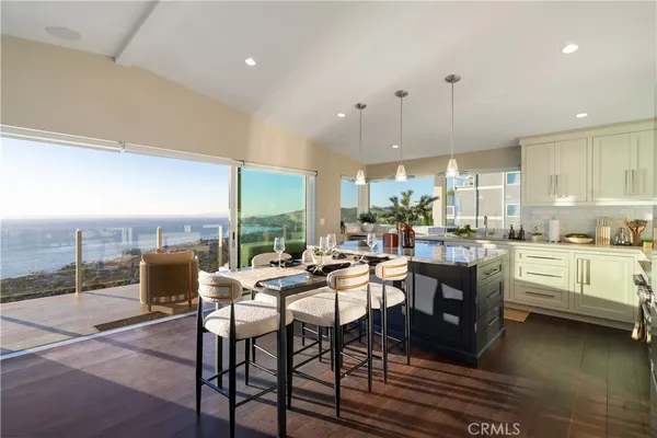 a living room with furniture kitchen view and a large window