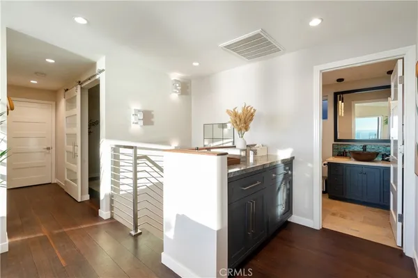 a hallway with a potted plant on the kitchen counter top and sink