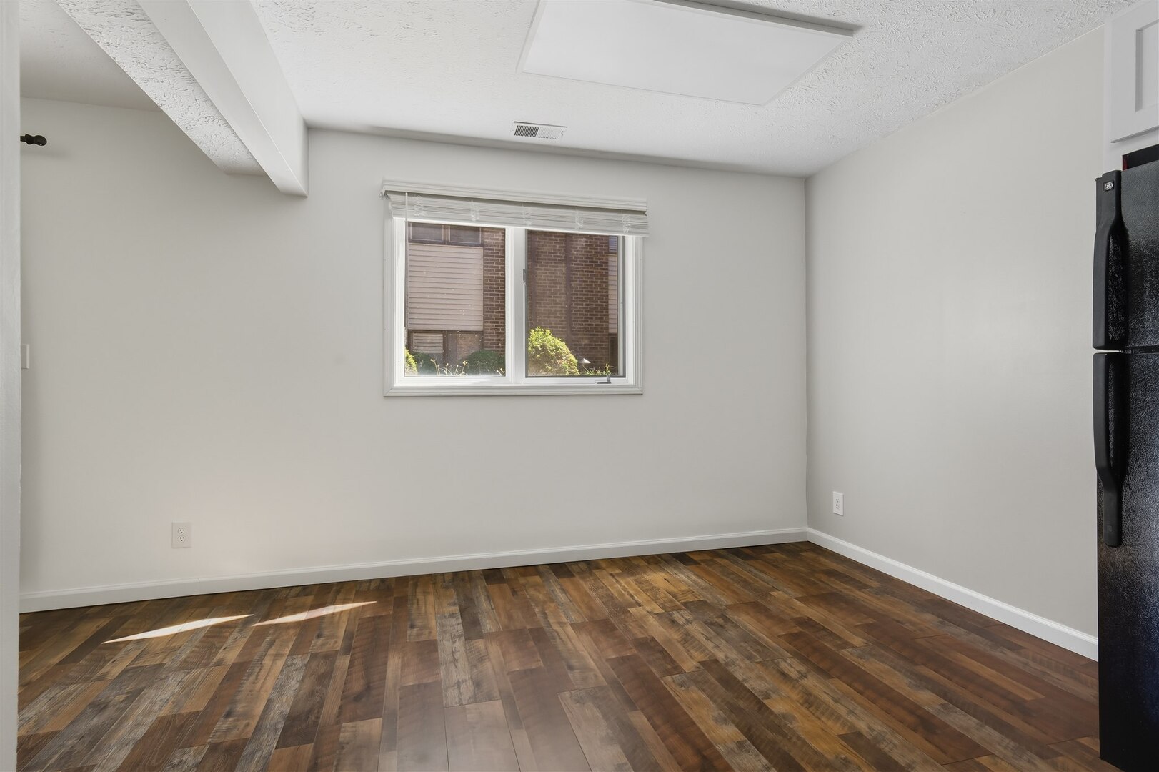 1916 Tracy Drive, Unit 26 Bloomington, IL 61704 - Photo 12 of 23 a view of an empty room with wooden floor and a window