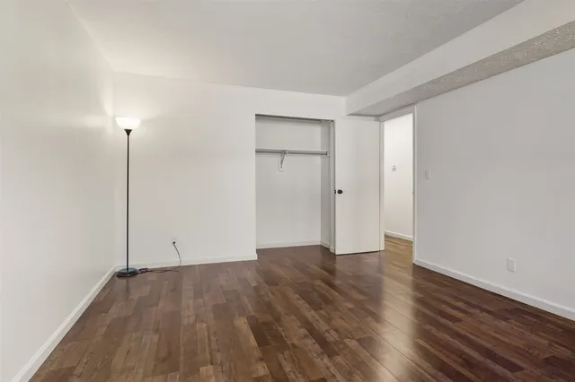 an empty room with wooden floor and closet