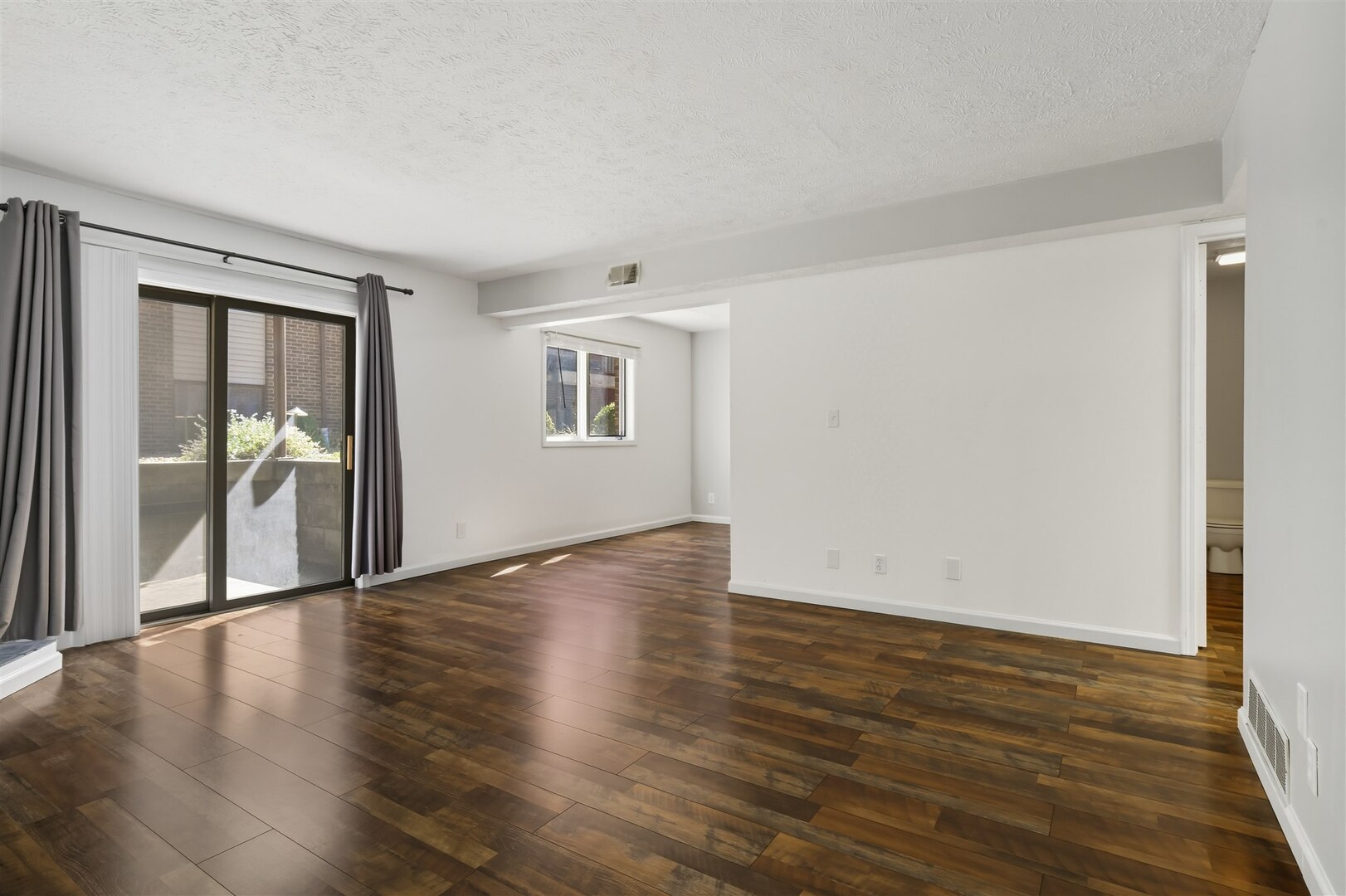 1916 Tracy Drive, Unit 26 Bloomington, IL 61704 - Photo 6 of 23 a view of an empty room with wooden floor and a window
