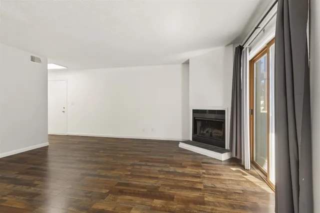a view of a room with wooden floor and a window