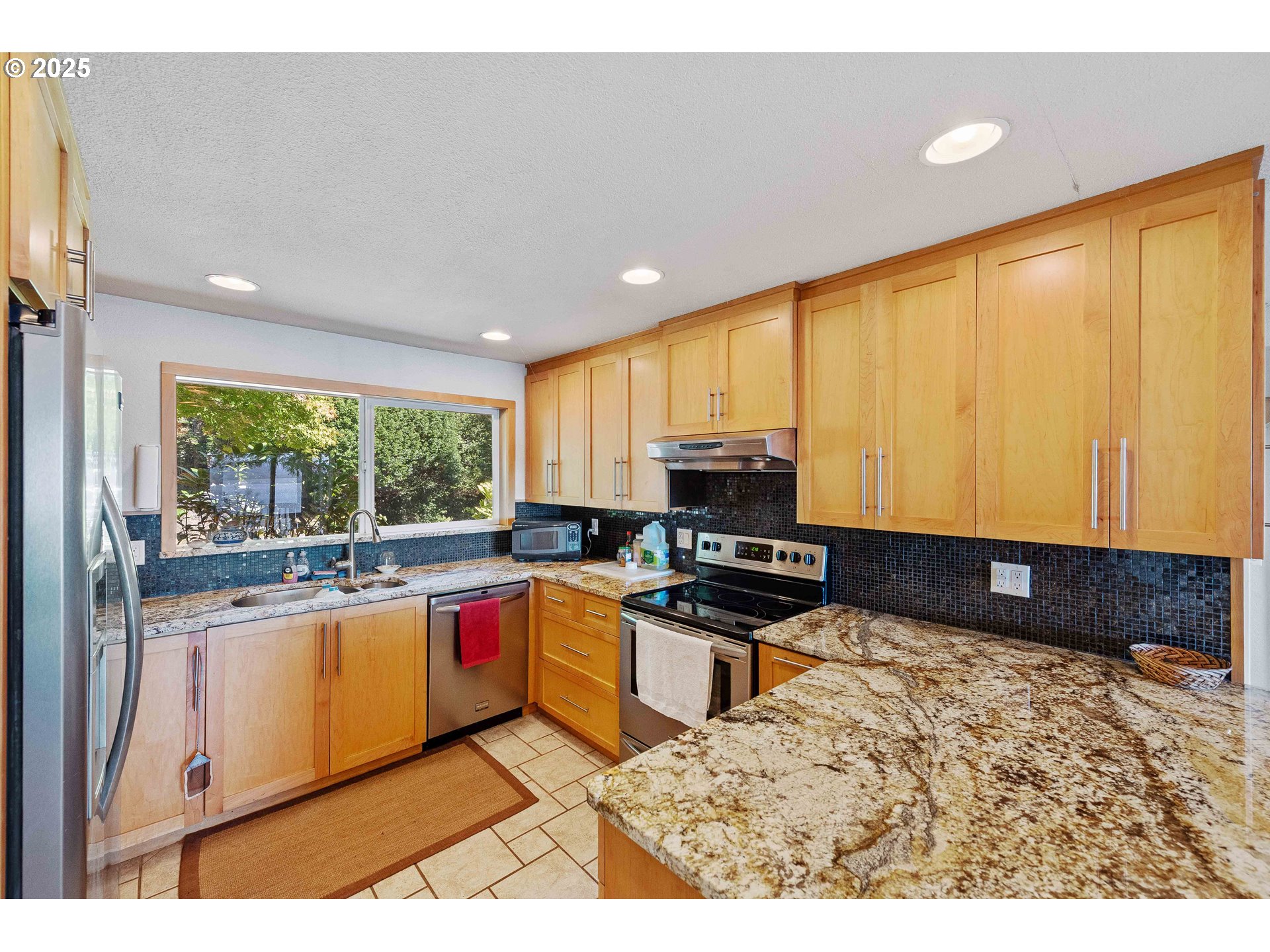 64662 East Bay Road North Bend, OR 97459 - Photo 19 of 48 a kitchen with stainless steel appliances granite countertop a stove a sink and a microwave