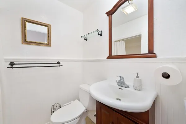 a bathroom with a sink mirror and toilet