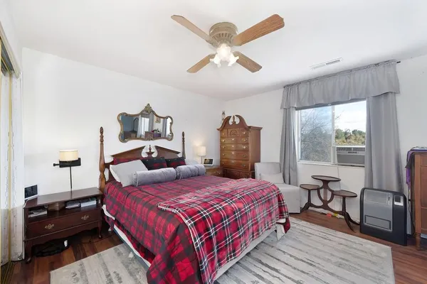 a bedroom with a bed and wooden floor
