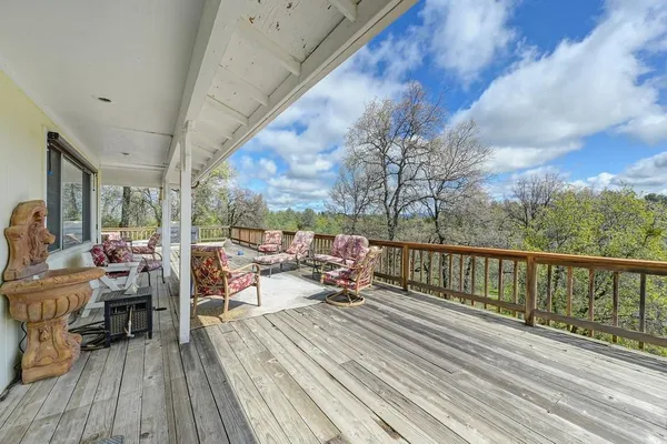 a view of a balcony with chairs and wooden floor
