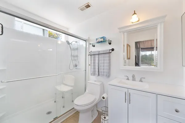 a bathroom with a sink a toilet and shower