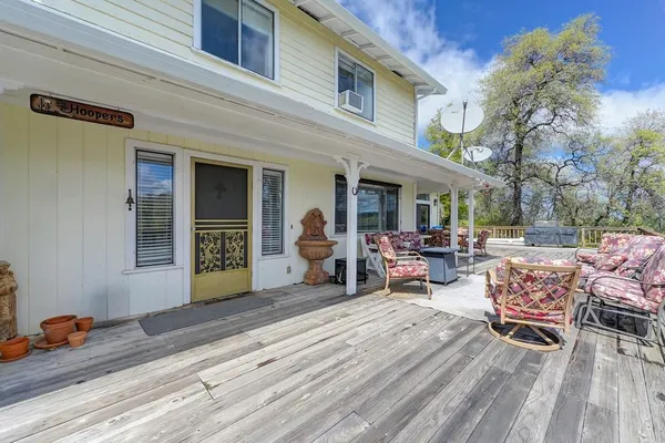 a view of a patio with dining table and chairs with wooden floor and fence