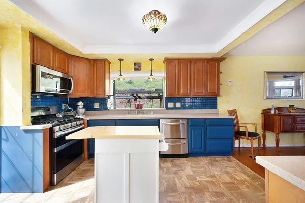 a kitchen with stainless steel appliances granite countertop a stove a sink dishwasher and a microwave oven with white cabinets