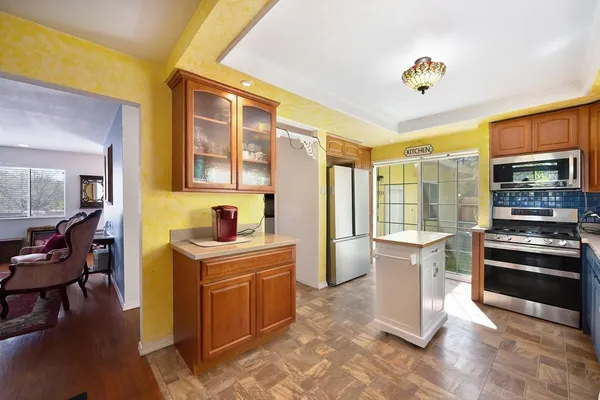 a view of a kitchen with a stove top oven a sink dishwasher a dining table and chairs with wooden floor