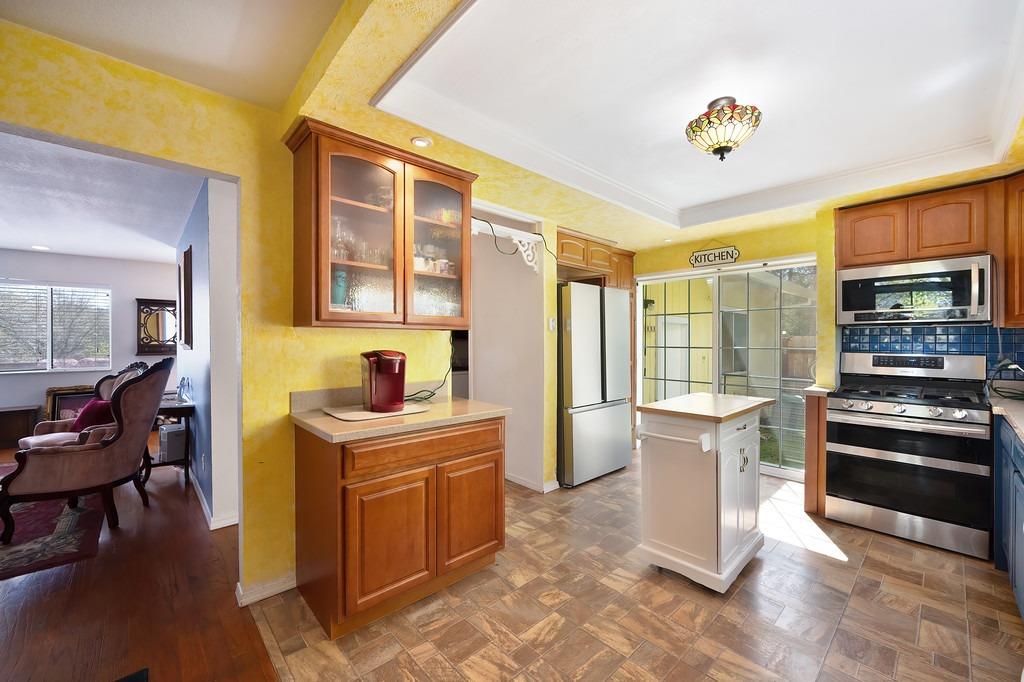 6930 Loggers Hollow Road Somerset, CA 95684 - Photo 9 of 42 a view of a kitchen with a stove top oven a sink dishwasher a dining table and chairs with wooden floor