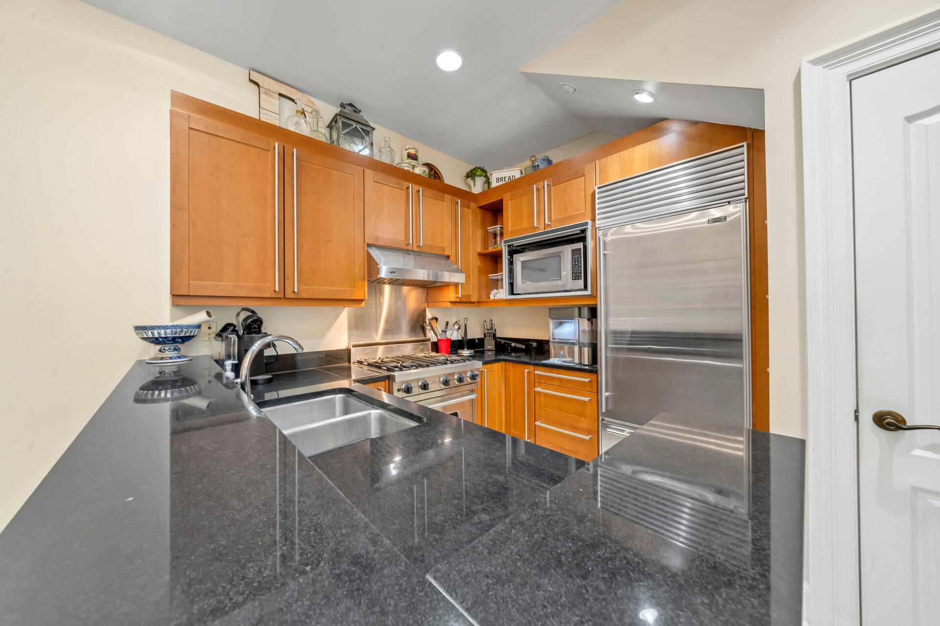 9201 Market Street Inn, Unit 162 Miramar Beach, FL 32550 - Photo 26 of 67 a kitchen with stainless steel appliances granite countertop a refrigerator a stove and a sink with wooden floor