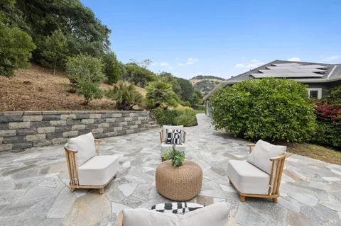a view of a chairs and table in backyard of the house