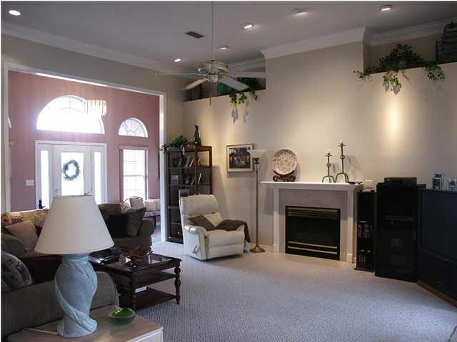 2585 Crescent Road Navarre, FL 32566 - Photo 5 of 7 a living room with furniture a fireplace and a chandelier
