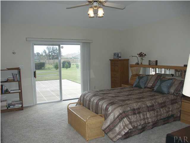 2585 Crescent Road Navarre, FL 32566 - Photo 7 of 7 a bedroom with a large bed and a chandelier