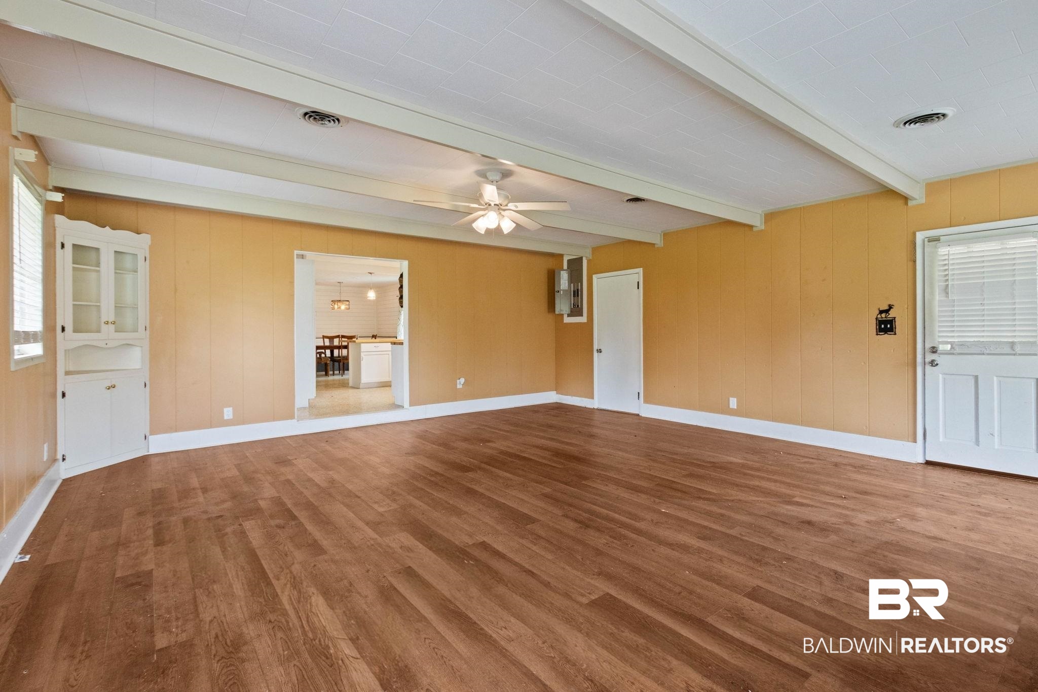 384 Old Bratt Road Atmore, AL 36502 - Photo 10 of 64 Spacious interior room featuring wood-finish flooring, exposed ceiling beams, a built-in corner cabinet, and a ceiling fan