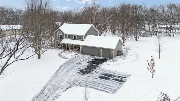 a view of a white house with a yard covered in snow