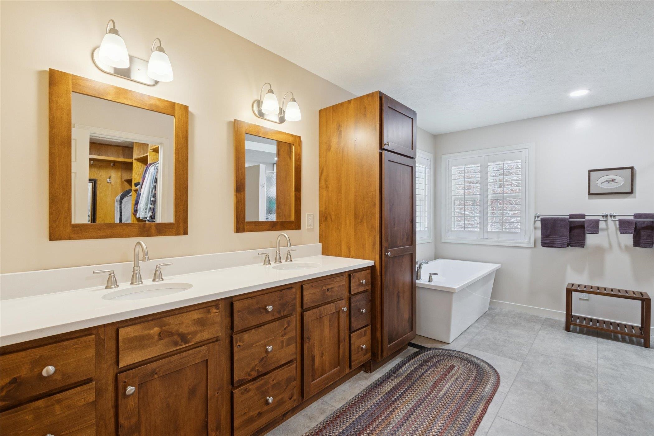 10906 Hamborg Road Roscoe, IL 61073 - Photo 37 of 65 a spacious bathroom with a double vanity sink a large mirror and a bathtub
