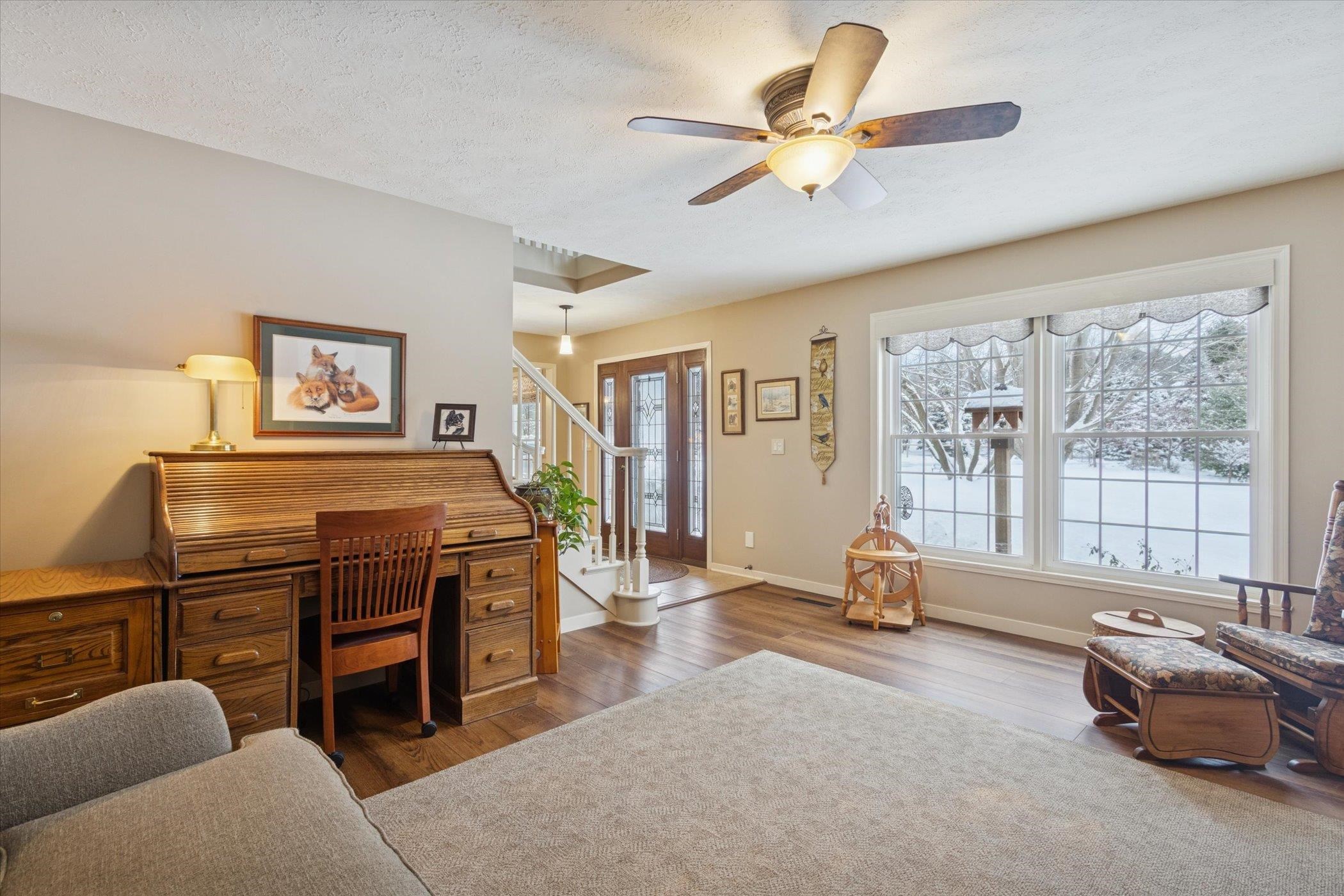 10906 Hamborg Road Roscoe, IL 61073 - Photo 10 of 65 a living room with furniture a ceiling fan and a large window
