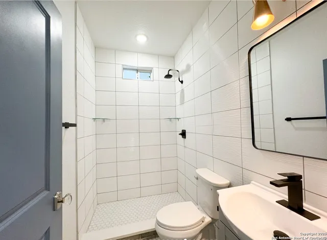 a bathroom with a toilet a sink and shower