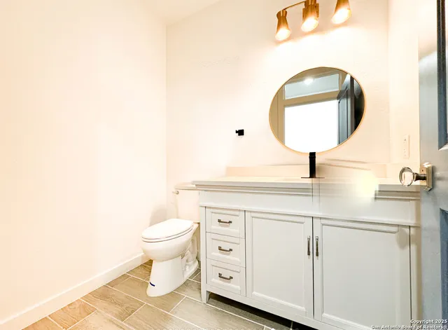 a bathroom with a toilet a sink and a mirror
