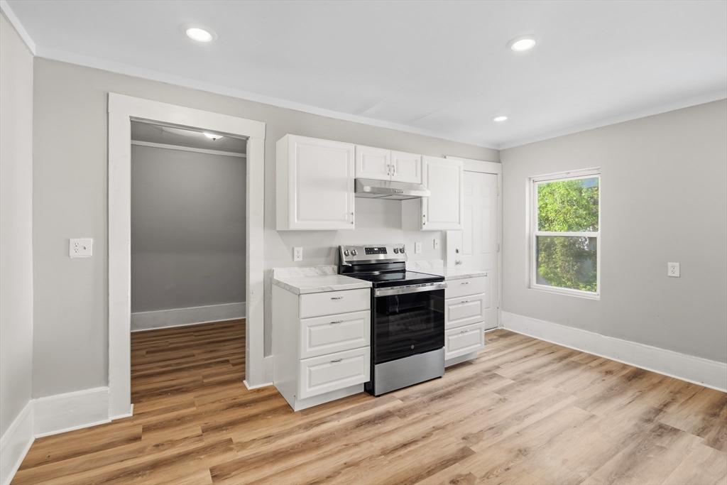 834 Worthington Street, Unit 2 Springfield, MA 01105 - Photo 5 of 20 a kitchen with granite countertop a stove and a refrigerator