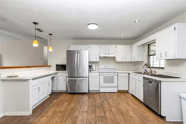 a kitchen with white cabinets and stainless steel appliances
