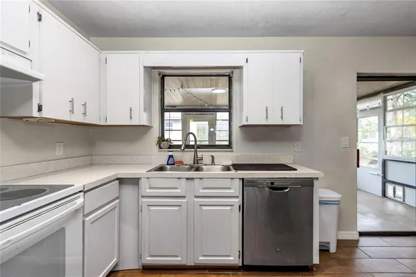 a kitchen with cabinets appliances a sink and a window