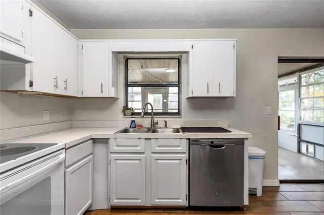 a kitchen with cabinets appliances a sink and a window