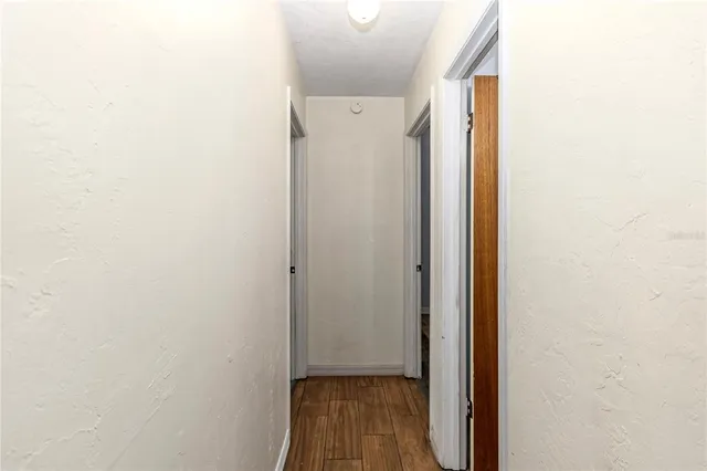 a view of a hallway with wooden floor