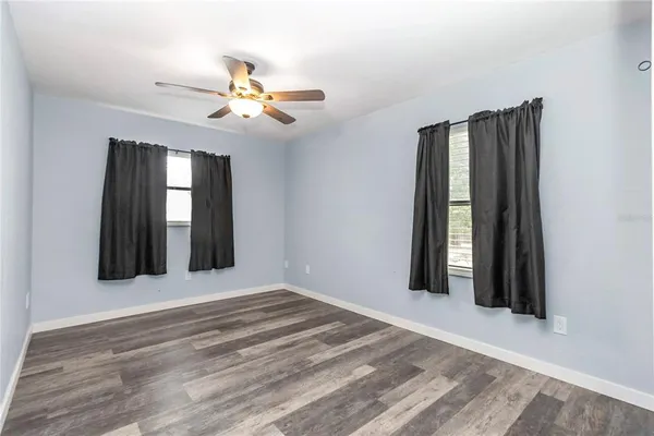 a view of a room with a ceiling fan and wooden floor