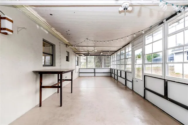 a view of empty room with windows and ceiling fan