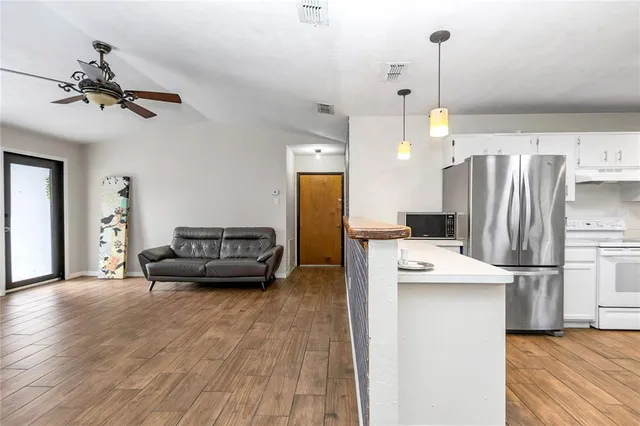 a living room with furniture and kitchen view