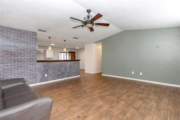 a view of a livingroom with a ceiling fan and kitchen view