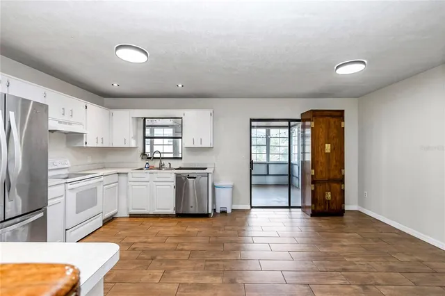 a kitchen with stainless steel appliances granite countertop a refrigerator and a stove top oven