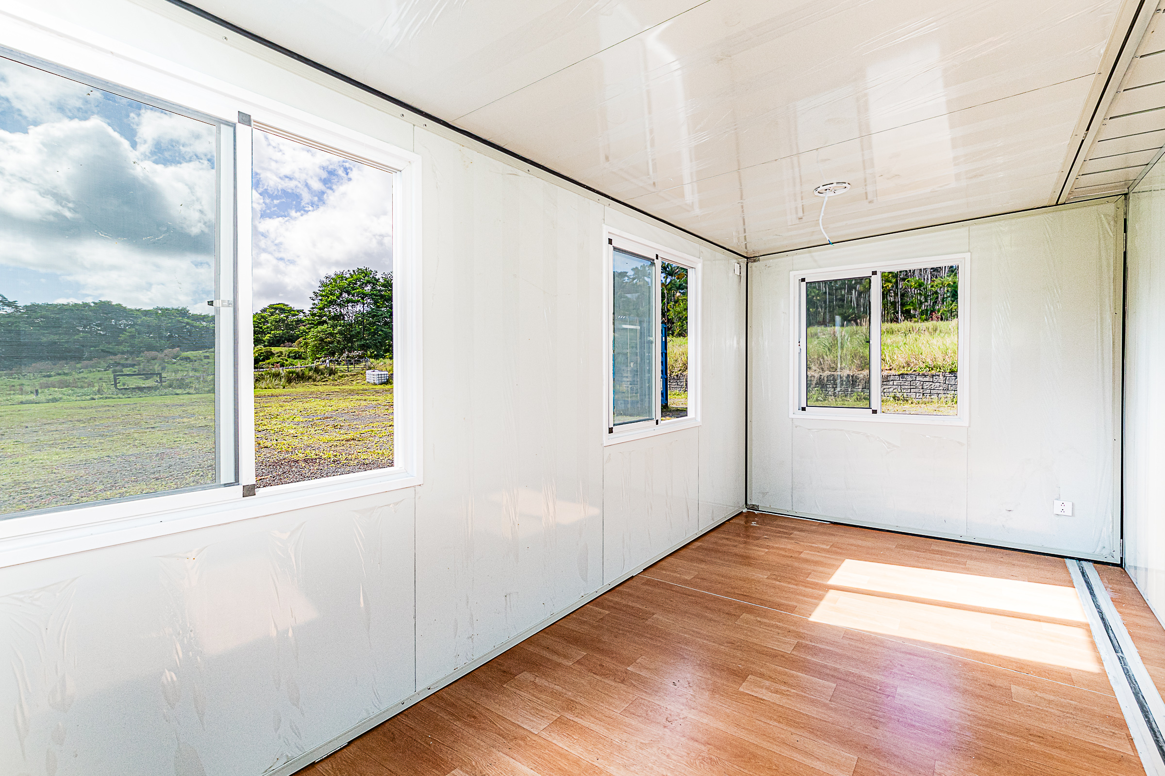 681 Hoaka Road Hilo, HI 96720 - Photo 20 of 26 a view of an empty room with wooden floor and a window