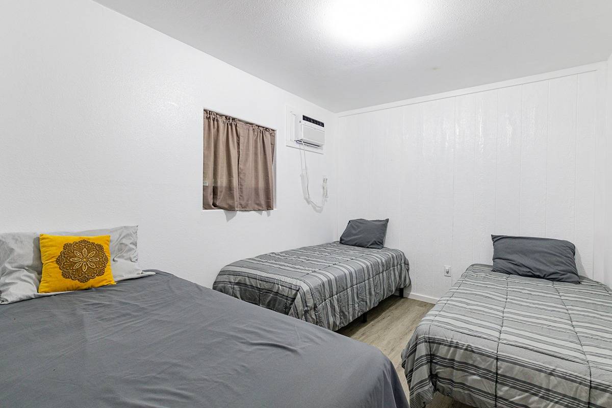 681 Hoaka Road Hilo, HI 96720 - Photo 9 of 26 a bedroom with two beds and painting on the wall