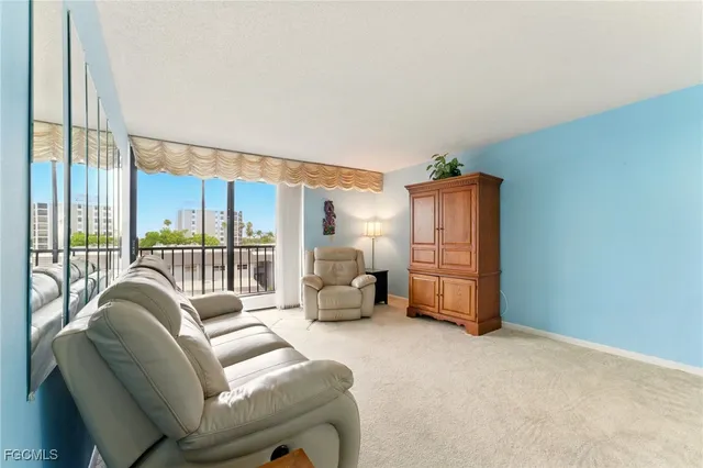 a living room with furniture cabinets and a floor to ceiling window