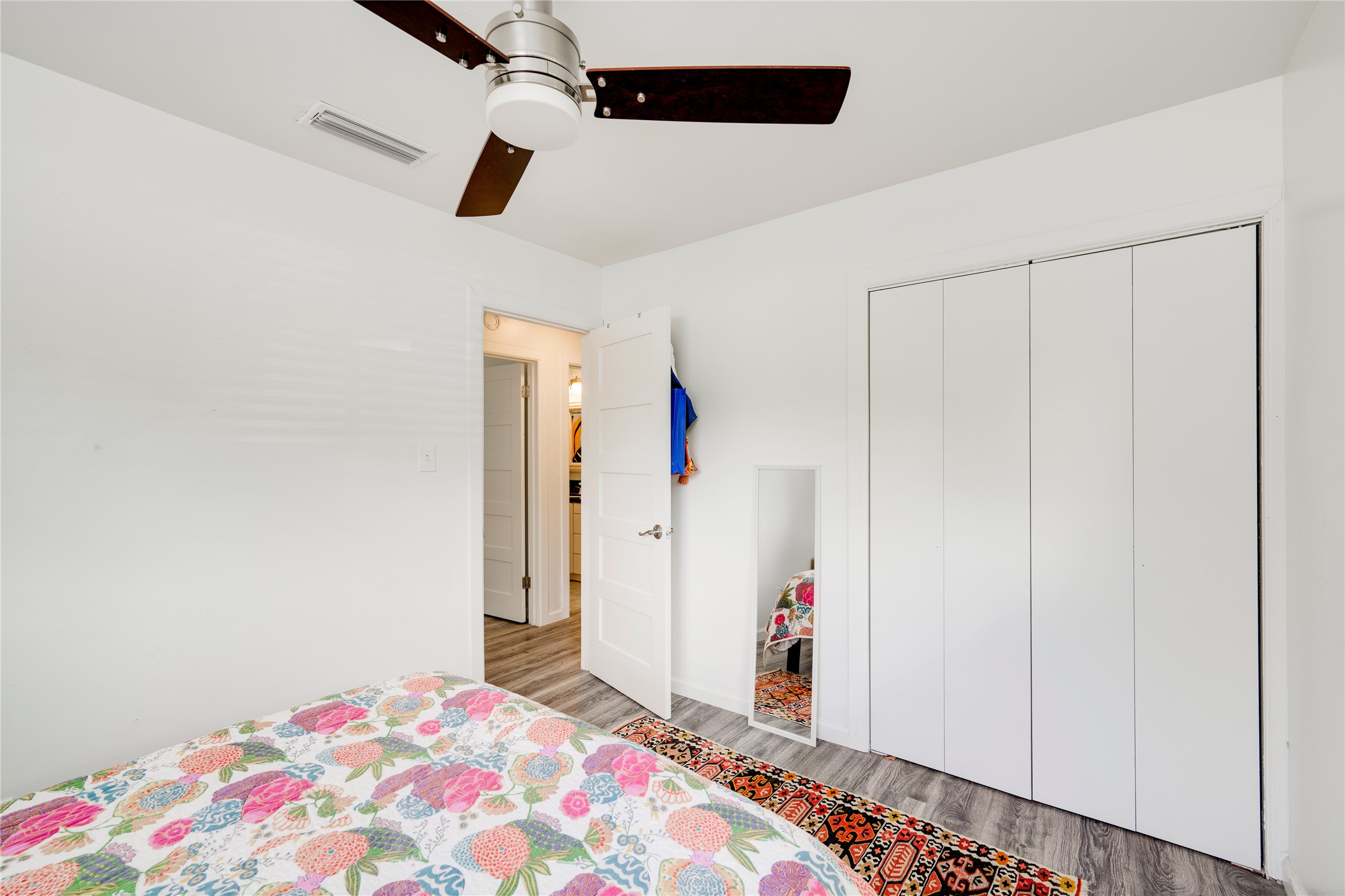 5300 Halmark Drive Austin, TX 78723 - Photo 18 of 40 A quiet retreat with a functional ceiling fan, featuring durable vinyl plank flooring and an integrated closet for essential storage.