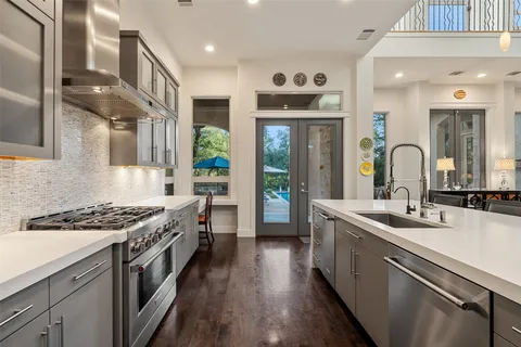 a kitchen with a sink a counter top space and stainless steel appliances