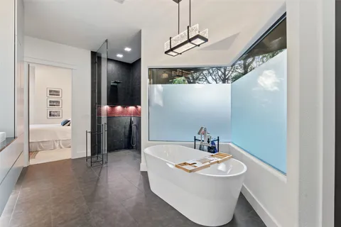 a bathroom with a tub sink and mirror