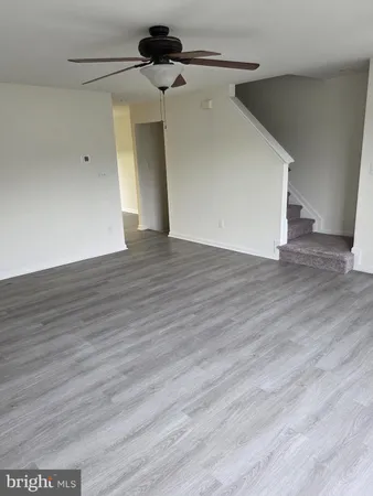a view of a hallway with wooden floor and a ceiling fan