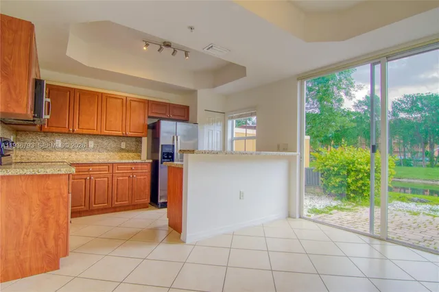 a kitchen with stainless steel appliances granite countertop a refrigerator and a stove top oven