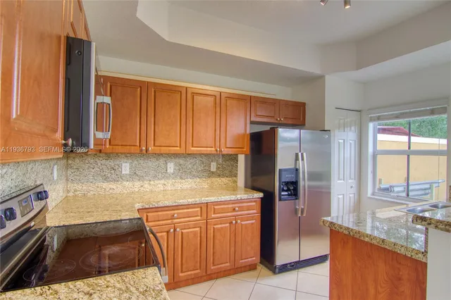 a kitchen with stainless steel appliances granite countertop a sink and a stove