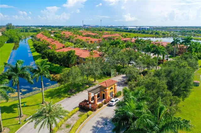 an aerial view of residential houses with outdoor space and trees